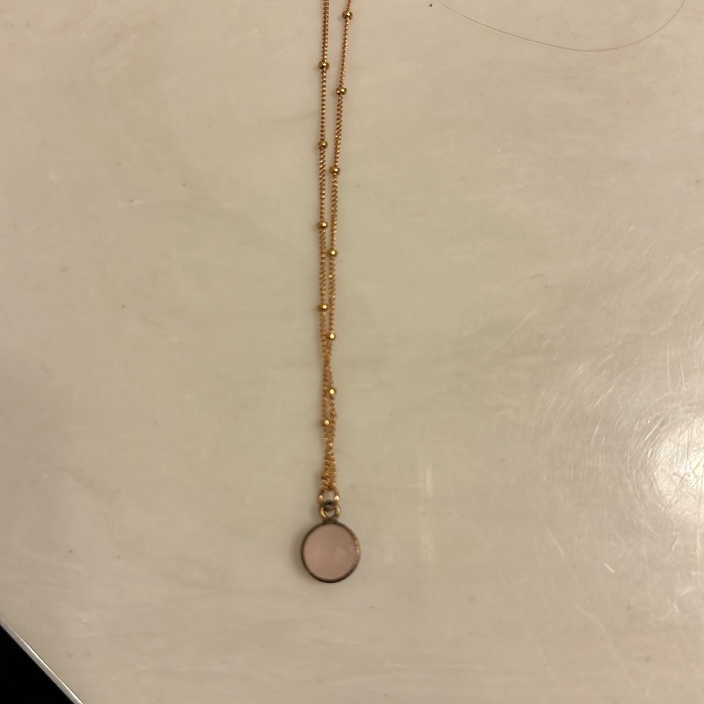 Pink charm necklace on a dark gold chain